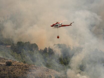 Un helicóptero de los Servicios de Emergencia trabaja en la extinción del incendio forestal de Tàrbena, este lunes.