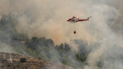 Un helicóptero de los Servicios de Emergencia trabaja en la extinción del incendio forestal de Tárbena el pasado lunes.