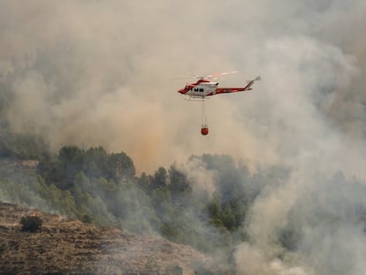 Un helicóptero de los Servicios de Emergencia trabaja en la extinción del incendio forestal de Tàrbena, este lunes.