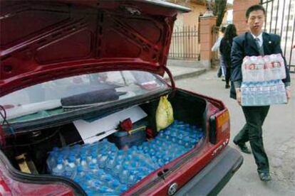 Un residente en Harbin hace acopio de agua embotellada.