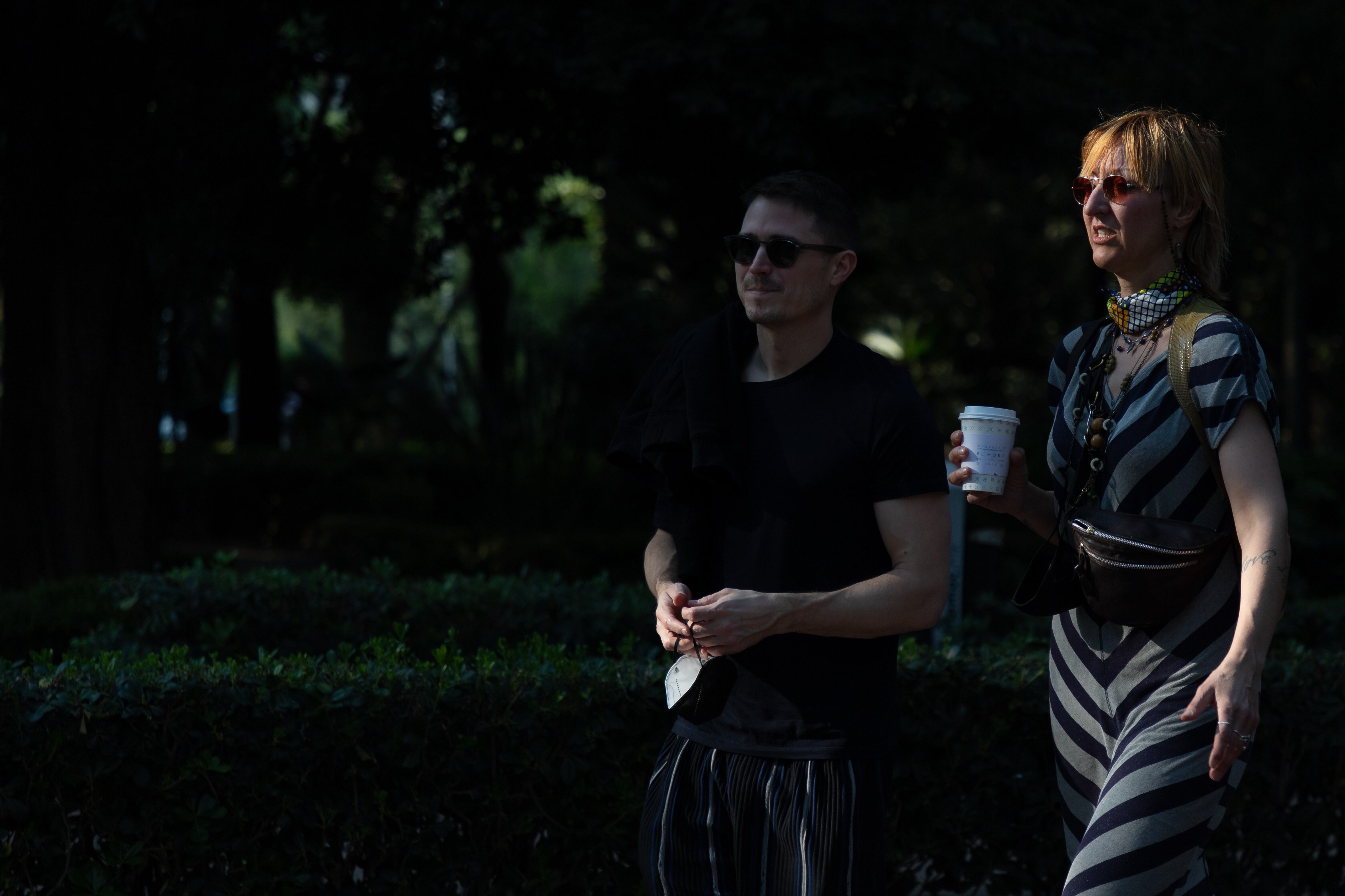 Una pareja camina por el Parque México en la colonia Condesa.