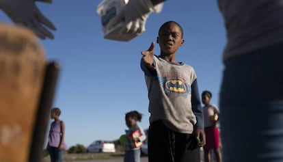 Un niño residente en el asentamiento informal de Masincedane, en Ciudad del Cabo (Sudáfrica) recibe una ración de comida de parte de una organización benéfica el pasado 28 de abril de 2020.