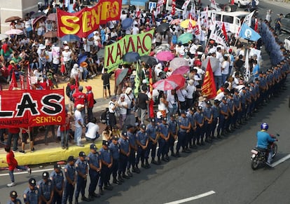 La policía rodea a los manifestantes mientras estos celebran un mitin en una rotonda para protestar por los continuos asesinatos bajo el gobierno del presidente Rodrigo Duterte contra las drogas y para conmemorar la celebración del Día Internacional del Trabajo, en Manila (Filipinas).