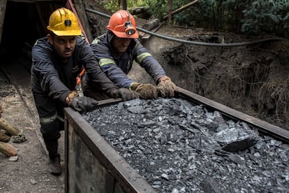 Dos mineros empujan un vagón de carbón fuera de una mina en Cucunuba, Colombia.