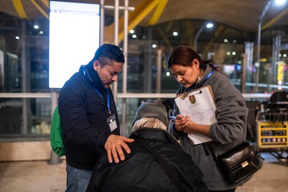 
Dos miembros de la iglesia evangélica Cristo Vive oran junto a una persona sin hogar de Barajas a finales de enero. 
