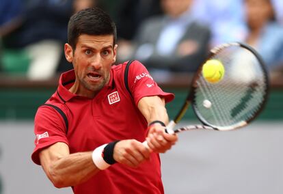 El tenista serbio, Novak Djokovic, golpea la pelota lanzada por Andy Murray.