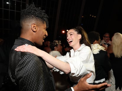El cantante y compositor estadounidense Jon Batiste saluda a la actriz Anne Hathaway dentro del Museo Metropolitano de Nueva York durante la gala que homenajea el dandismo de los hombres negros.