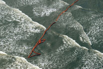 Varias barreras se deslizan entre las olas para impedir que la mancha llegue a la costa en Lousiana.