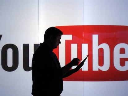 Un hombre pasa por delante del logo de YouTube.