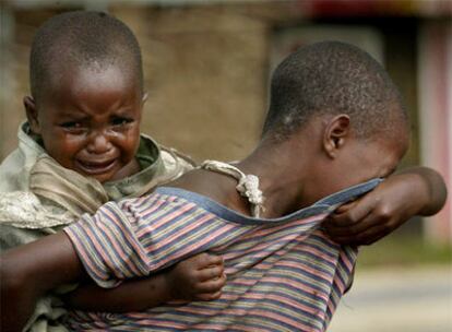 Una niña con su sobrina a cuestas busca a sus padres de los que se separó mientras huían de Kiwaqnja (este de Congo).