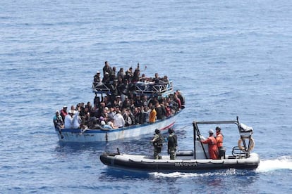 El equipo de salvamento aborda una barcaza con migrantes para rescatarlos.