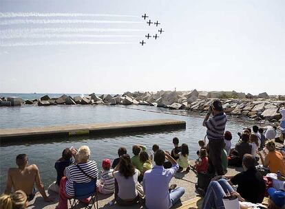 Un grupo de espectadores sigue las piruetas de la patrulla Águila, que vuela en formación frente al Fórum.