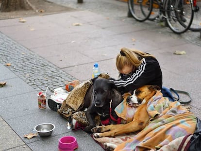 Una indigente, junto a dos perros en una calle de Berlín.