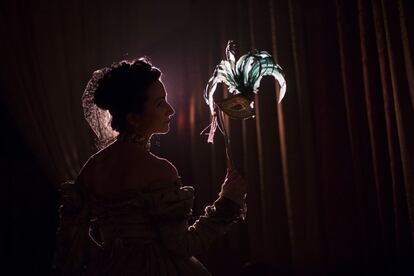 Retrato contra a luz de uma mulher que segura uma máscara no Palácio Clam-Gallas, em Praga, durante o carnaval.