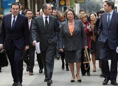 Francisco Camps, arropado por su Gobierno y la alcaldesa Rita Barberá, ayer, cuando se dirigía desde el Palau de la Generalitat a las Cortes Valencianas.