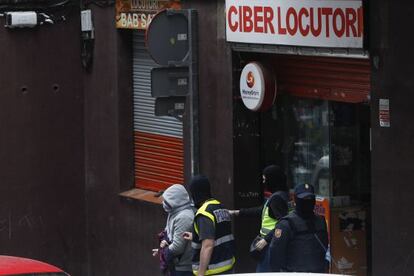 La policia amb el detingut a Mataró, després del registre al locutori.