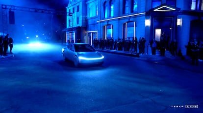 A Tesla robotaxi drives past the public during its unveiling in Los Angeles.