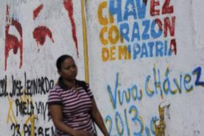Una mujer camina junto a un letrero pintado con un mensaje alusivo al presidente de Venezuela, Hugo Chávez, el 8 de febrero de 2013, en las calles del centro de Caracas (Venezuela).