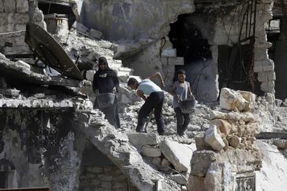 Una familia siria limpia los escombros de su casa destruida, en el barrio de Karm al-Jabal, al norte de Alepo (Siria).