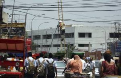 Un operario trabaja en uno de los cables del tendido eléctrico en medio de una bulliciosa calle de Amritsar, en Punjab (India). EFE/Archivo