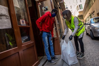 Una voluntaria de la ONG Acción Planetaria entrega un paquete con comida en la sede de la organización Top Manta.