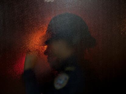 La silueta de una policía a través de la puerta de una sala de emergencias en un hospital de San Pedro Sula (Honduras).
