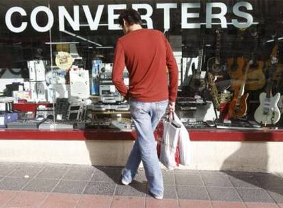 Un hombre ante el escaparate de una tienda de segunda mano en Madrid.