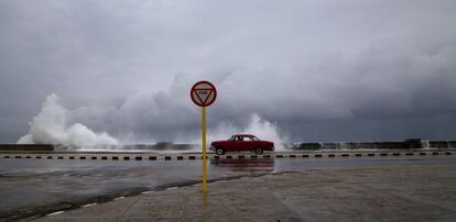 Un coche clásico americano utilizado como taxi circula por el Malecón en La Habana, Cuba.