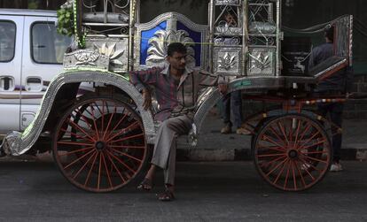 HO08 BOMBAY (INDIA) 19/03/2016.- Un cochero espera junto a su carruaje victoria cerca del Taj Mahal Palace Hotel en Bombay (India) el 23 de abril de 2016. Los coches de caballos victoria ya llevan desaparecidos de las calles de Bombay un año. La conocida atracción turística fue prohibida por el Tribunal Supremo de Bombay en junio de 2015, en defensa de los animales y de acuerdo con la Ley de Prevención de Crueldad a los Animales. Estos vehículos aparecieron en la época de la reina Victoria, un remanente de la época colonial británica. Estos coloridos carruajes se utilizaban para recorrer pequeñas distancias principalmente del Taj Mahal Palace hotel o el Trident Hotel a la Puerta de la India. EFE/Divyakant Solanki