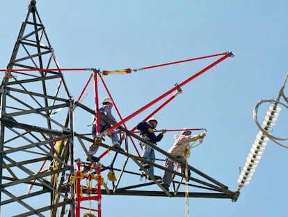 Tres operarios de REE trabajan en un tendido de alta tensión.