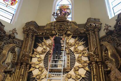 El bombero Felipe García baja el cuadro de la Virgen de La Paloma.