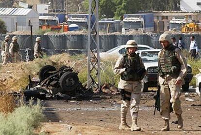Soldados estadounidenses patrullan el lugar donde explotó un coche bomba, ayer en Bagdad.