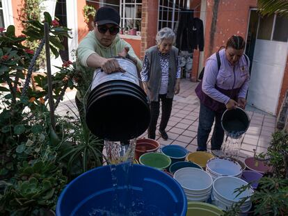 Fátima Espinosa e Ilda Ramírez llenan cubetas y botas de agua en Iztapalapa.