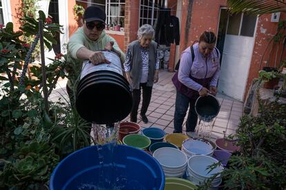 Fátima Espinosa e Ilda Ramírez llenan cubetas y botas de agua en Iztapalapa.