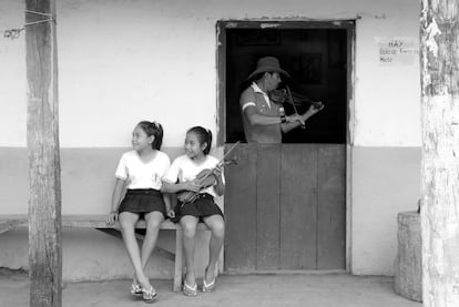 Dos niñas con un violín en la puerta de una casa de Urubichá, Guarayos (Santa Cruz).