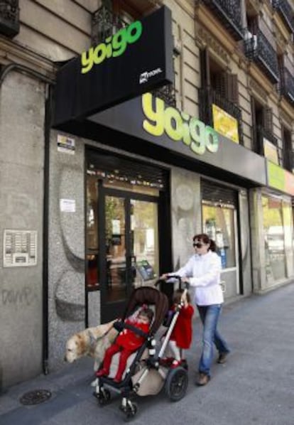 Una mujer pasa por delante de una Tienda de Yoigo. 