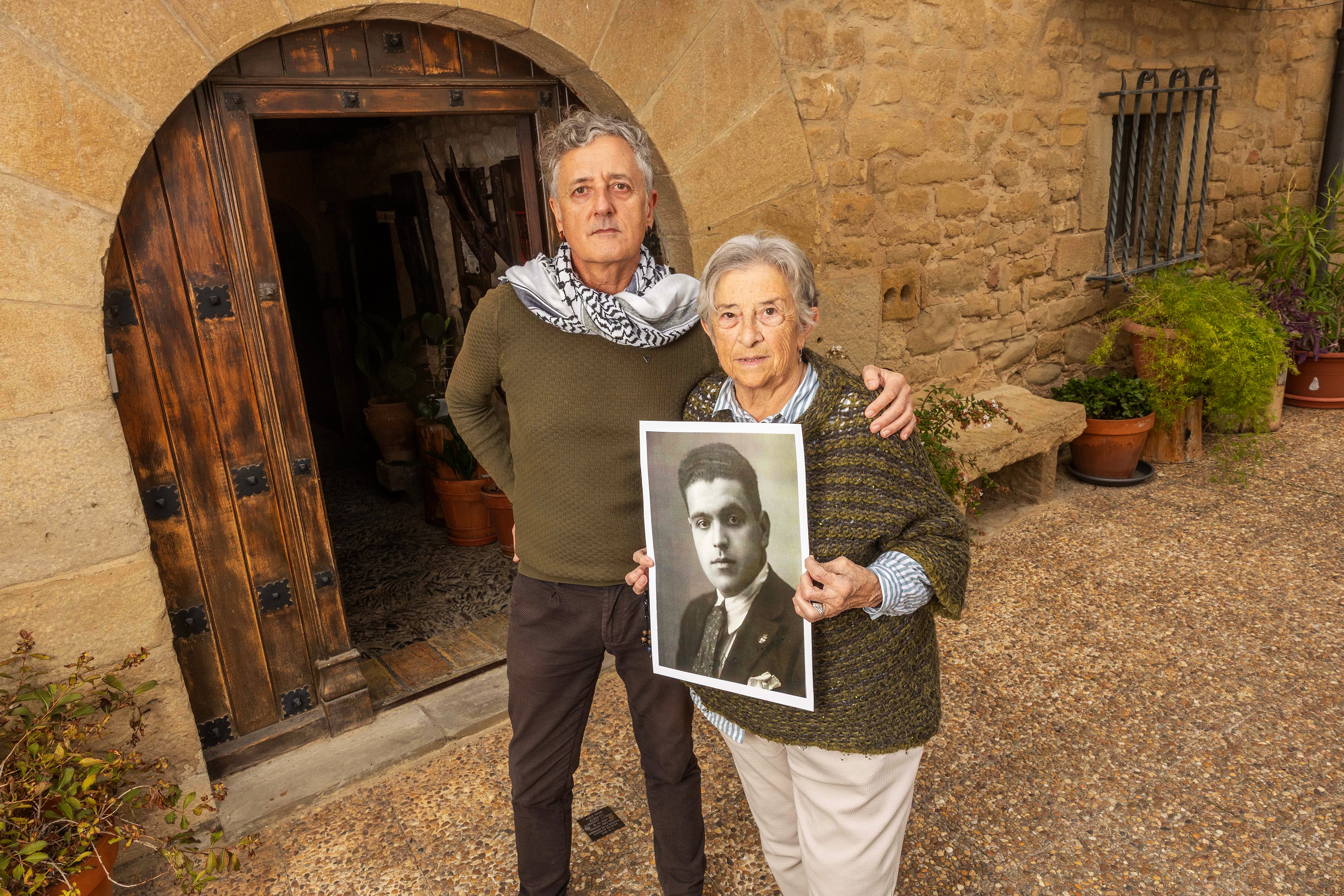 Alberto y Pili, familiares de Alberto Lorenzo Lamas, del que portan una foto, en una casa de Obanos (Navarra) donde este estuvo escondido.