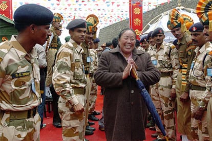 Una tibetana sonríe tras cruzar el paso de Nathu La, en la cordillera del Himalaya, ante la mirada de soldados chinos e indios.