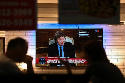 Clientes de un restaurante de Buenos Aires siguen por televisión este lunes la entrevista a Javier Milei.