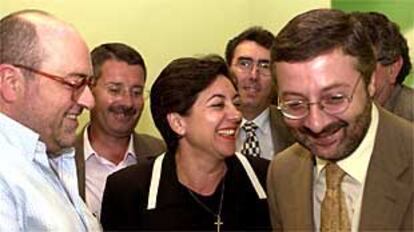 Los socialistas José Caballos e Isabel Pozuelo bromean con José Blanco tras la conferencia de prensa en la sede del PSOE sevillano.