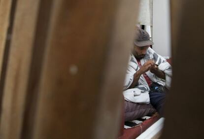 Homem acende um cachimbo de crack no centro.