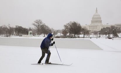 Un hombre esquía en las calles nevadas de Washington. Al fondo el edifico del Capitolio.