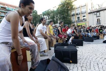 Aficionados, estudiantes y músicos de cajón alrededor del escenario en Lavapiés.