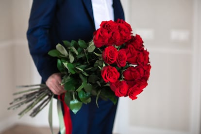 Un hombre sujeta un ramo de rosas.