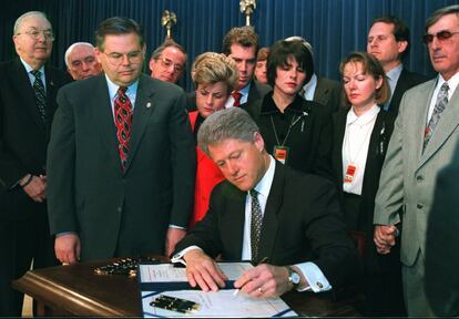 Congresistas y familiares de los pilotos abatidos en febrero rodean a Bill Clinton en la firma de la ley Helms-Burton, que endurece el embargo comercial contra Cuba por parte de los Estados Unidos, el 12 de marzo de 1996.