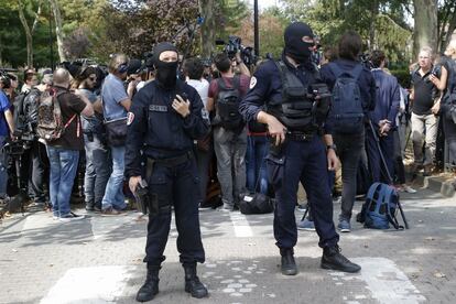 Policías vigilan la zona del ataque mientras el Ministro de Interior fracés habla con los medios de comunicación.