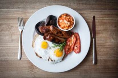 Desayuno inglés clásico: huevos, beicon, salchichas y alubias con tomate.