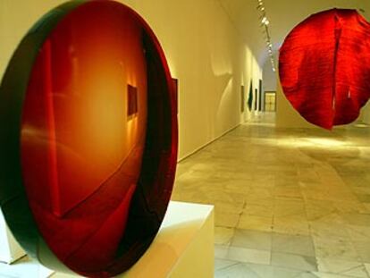 Una vista del entorno cromático del rojo de<i> Monocromos,</i> con<i> Lente roja</i> (1985), de Eversley, en primer término, y <i>Abakan rojo,</i> de Abakanowicz (1969), al fondo.