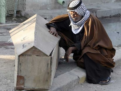 Un hombre llora junto al féretro de su hijo, muerto en el atentado del martes en la masacre de Tal Afar.