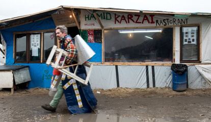 A migrant walks past a makeshift restaurant in the so-called "Jungle" migrant camp in Calais, on February 23, 2016.
A French court said on February 23, 2016 it was delaying its ruling on the demolition of half of the refugee camp in Calais known as the "Jungle", just hours before a deadline for residents to be evacuated. Emotions were running high in the "Jungle" on the outskirts of the northern port city of Calais, where many residents had refused to leave despite a 1900 GMT deadline to vacate the southern half of the camp. Local authorities say a total of 3,700 people are living in Jungle, and between 800 and 1,000 will be affected by the eviction. / AFP / DENIS CHARLET